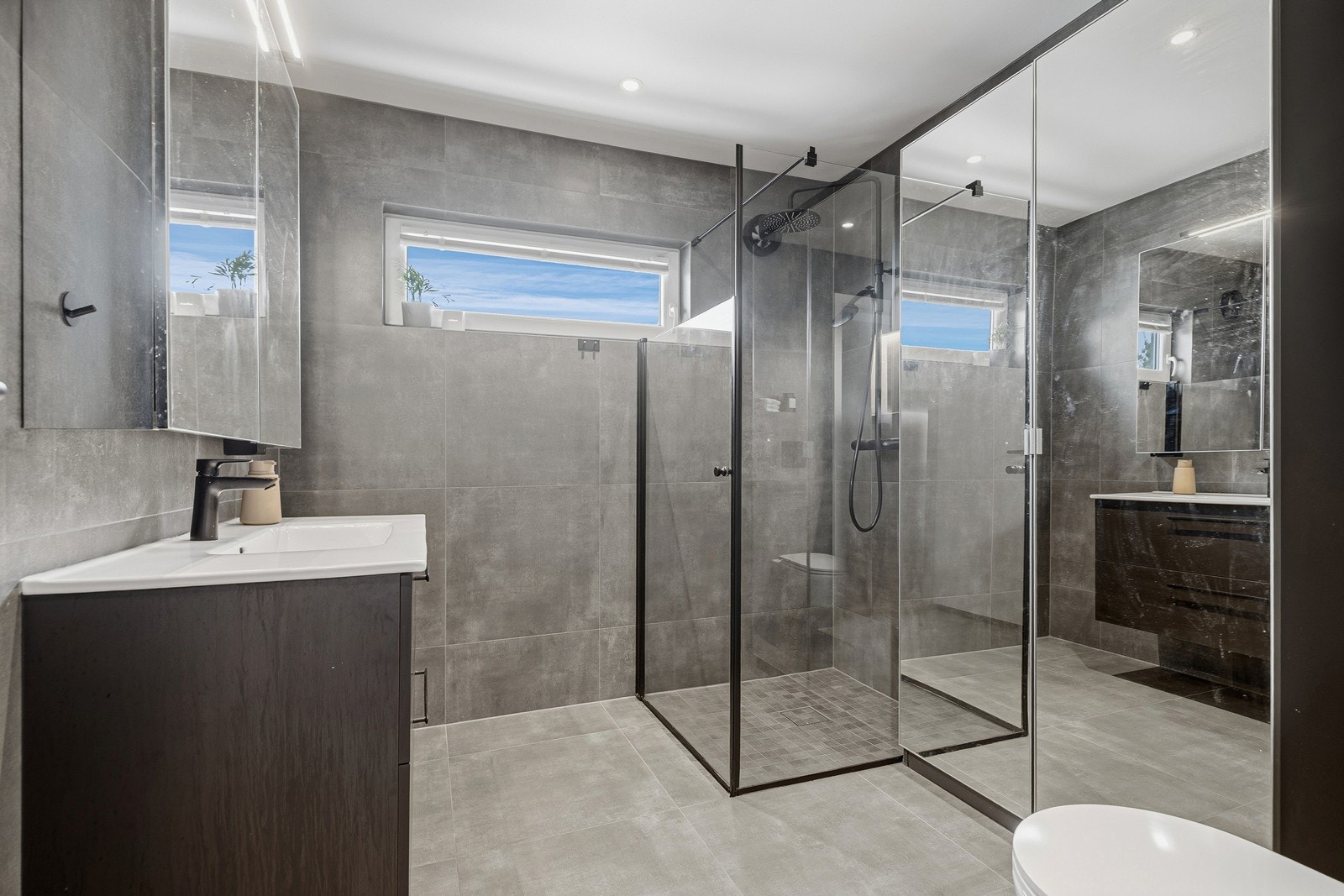 Lekkert baderom bestående av toalett, baderomsinnredning og dusjhjørne Galleribilde