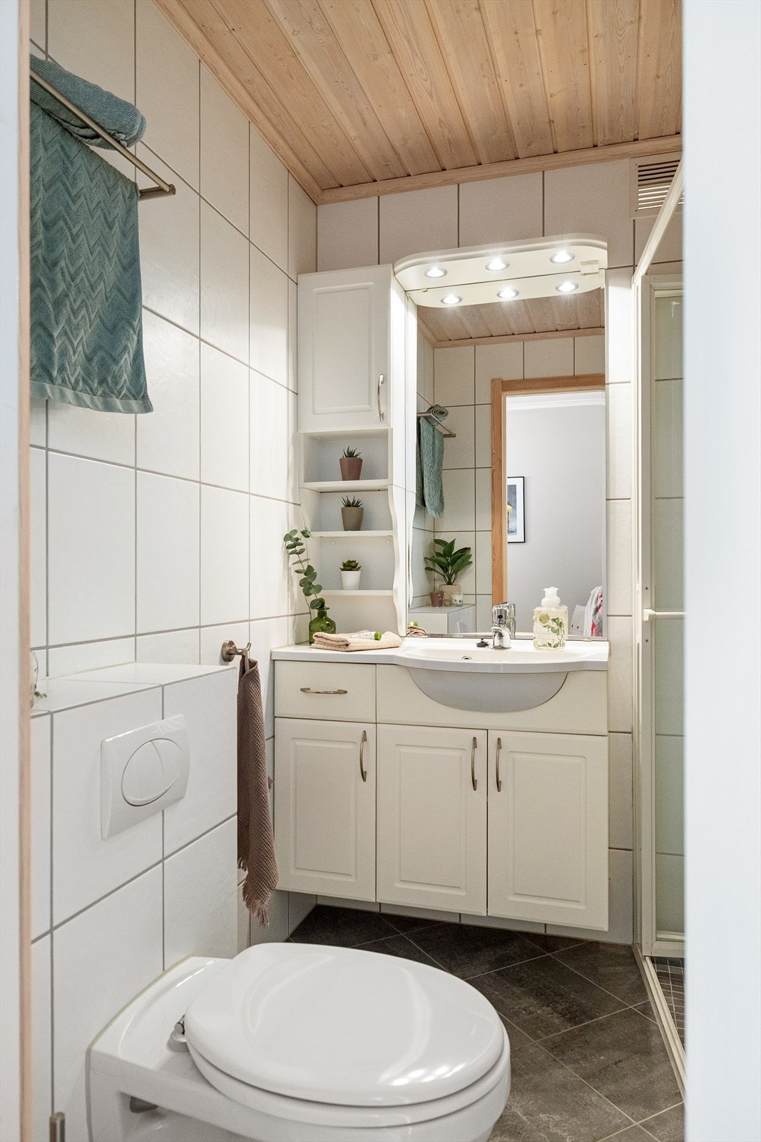 Tidløst bad fra 2003 med flislagte overflater og gulvvarme. Badet er utstyrt med toalett, dusjnisje og servant med ettgreps blandebatteri i innredning. Galleribilde