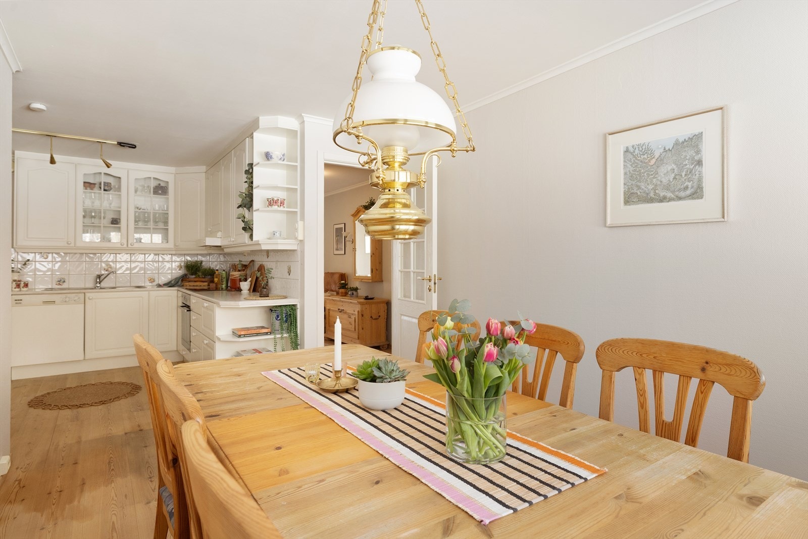 Norema-kjøkken fra 1997 med hvite, profilerte fronter, fliser på vegg over kjøkkenbenk og benkeplate i laminat. Galleribilde