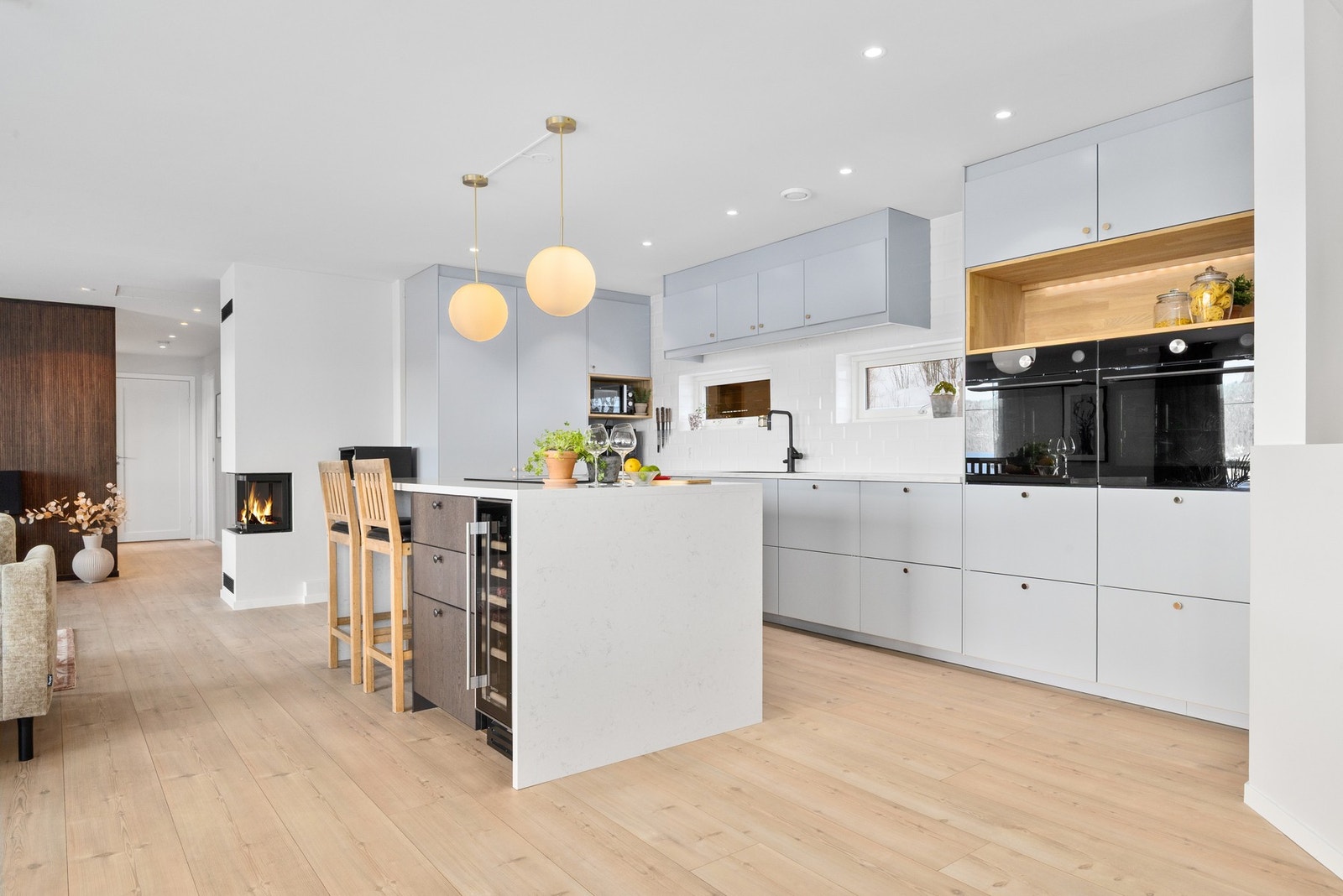 Den store kjøkkenøya fungerer som et naturlig samlingspunkt og har en eksklusiv steinbenkeplate i kvarts, som går helt ned til gulvet for et sømløst uttrykk. Foto: Marte Vibe Galleribilde