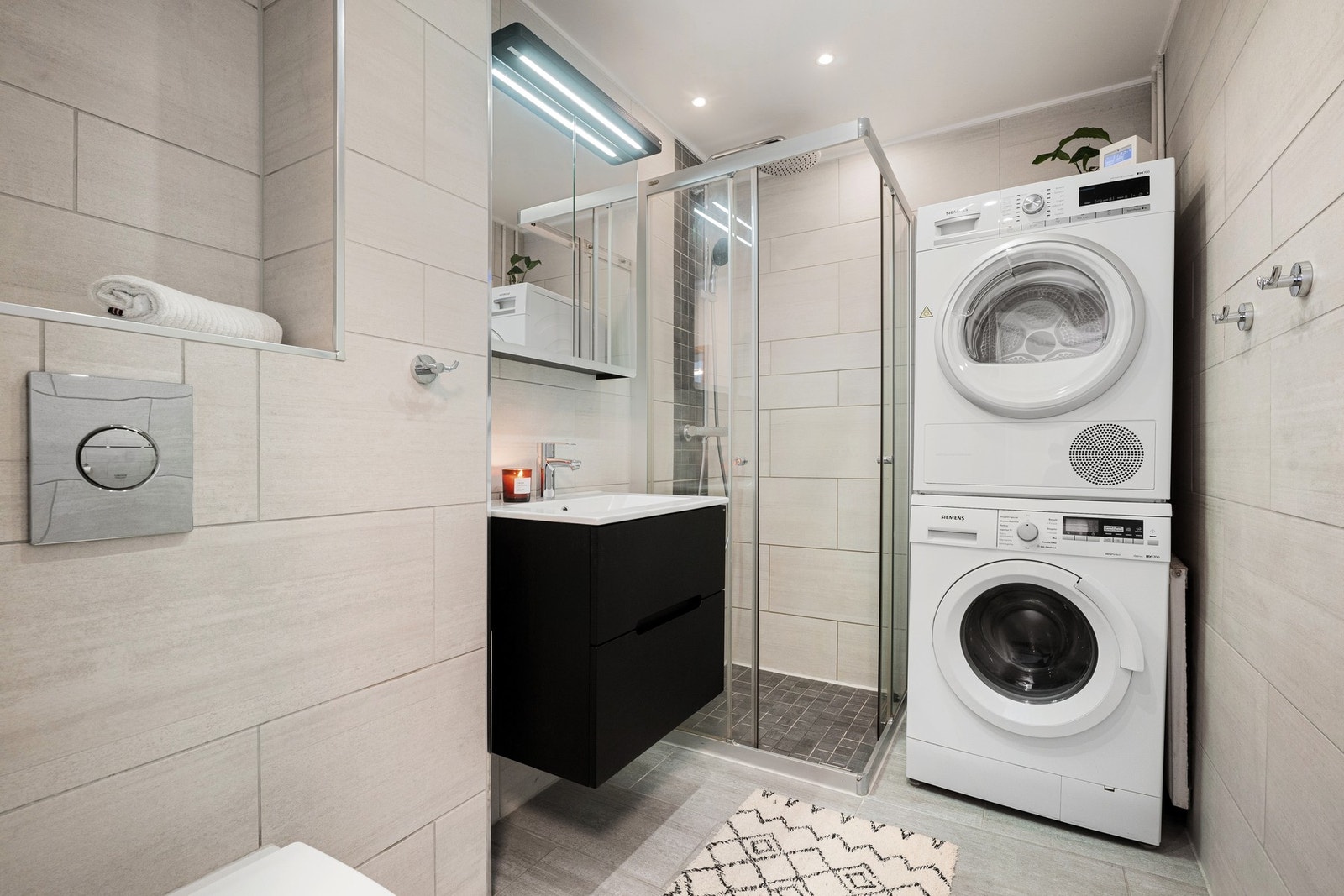 Lekkert flislagt bad med opplegg for vaskemaskin og tørketrommel Galleribilde