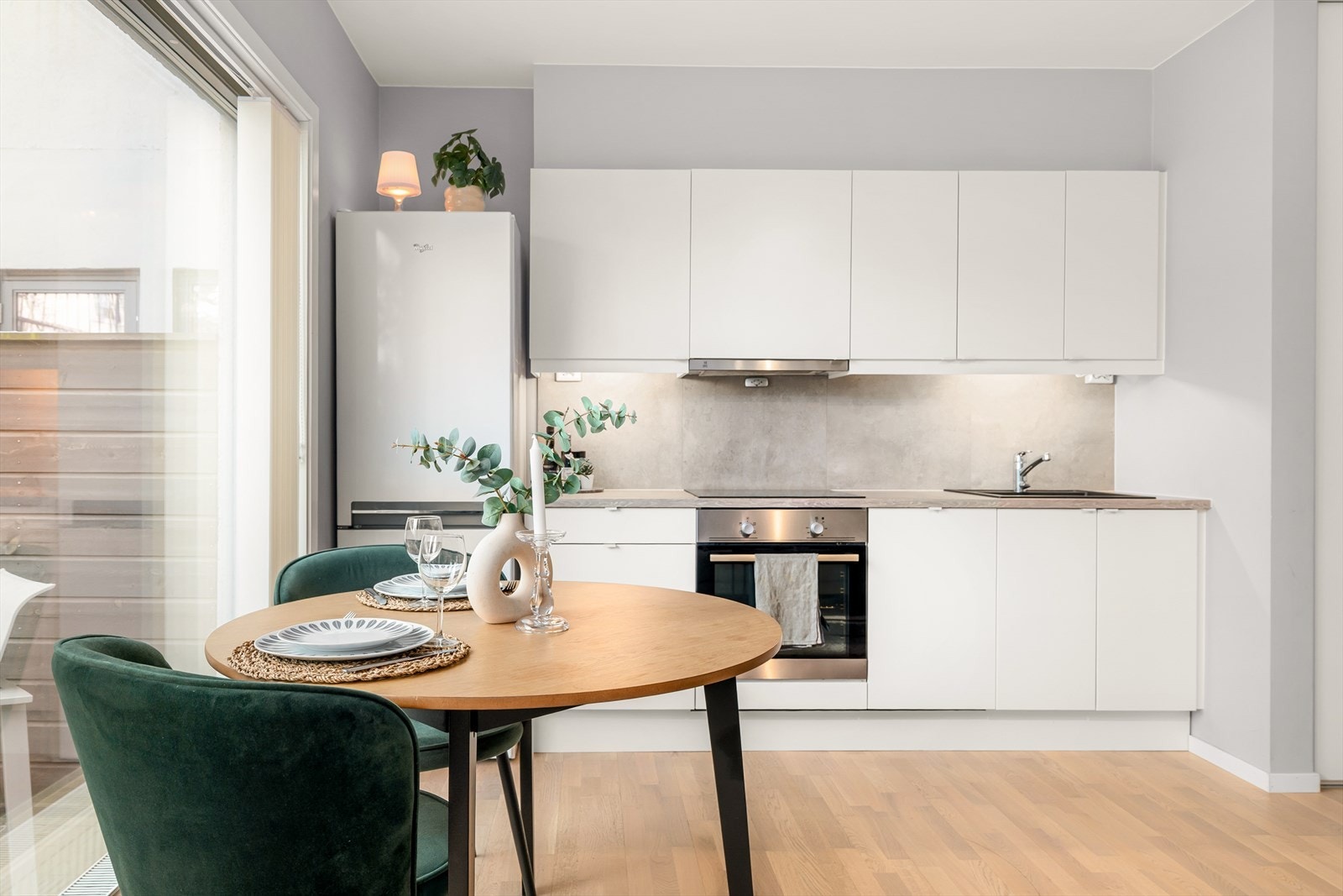 Benkeplaten i laminat har en nedfelt kum i kompositt og fliser over benken. Galleribilde