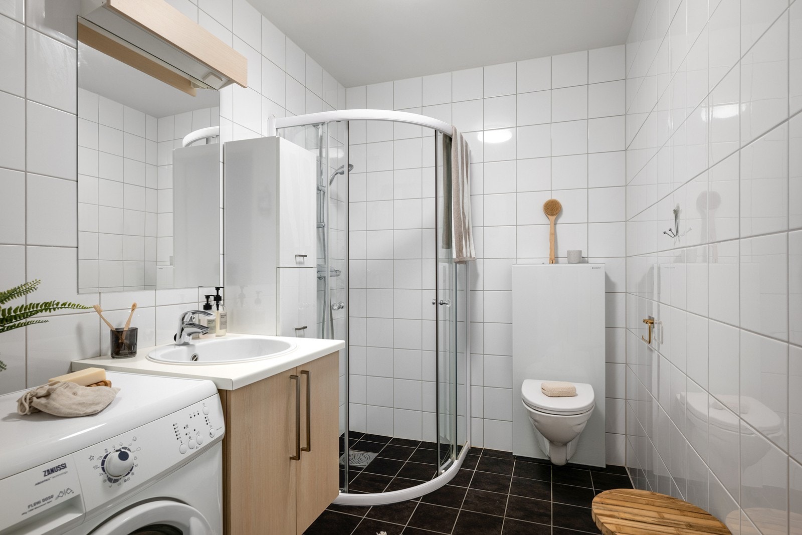 Servantinnredning, vegghengt toalett, dusjhjørne med glassdører og opplegg for vaskemaskin og tørketrommel. Gulvvarme gir god komfort i hverdagen. Galleribilde