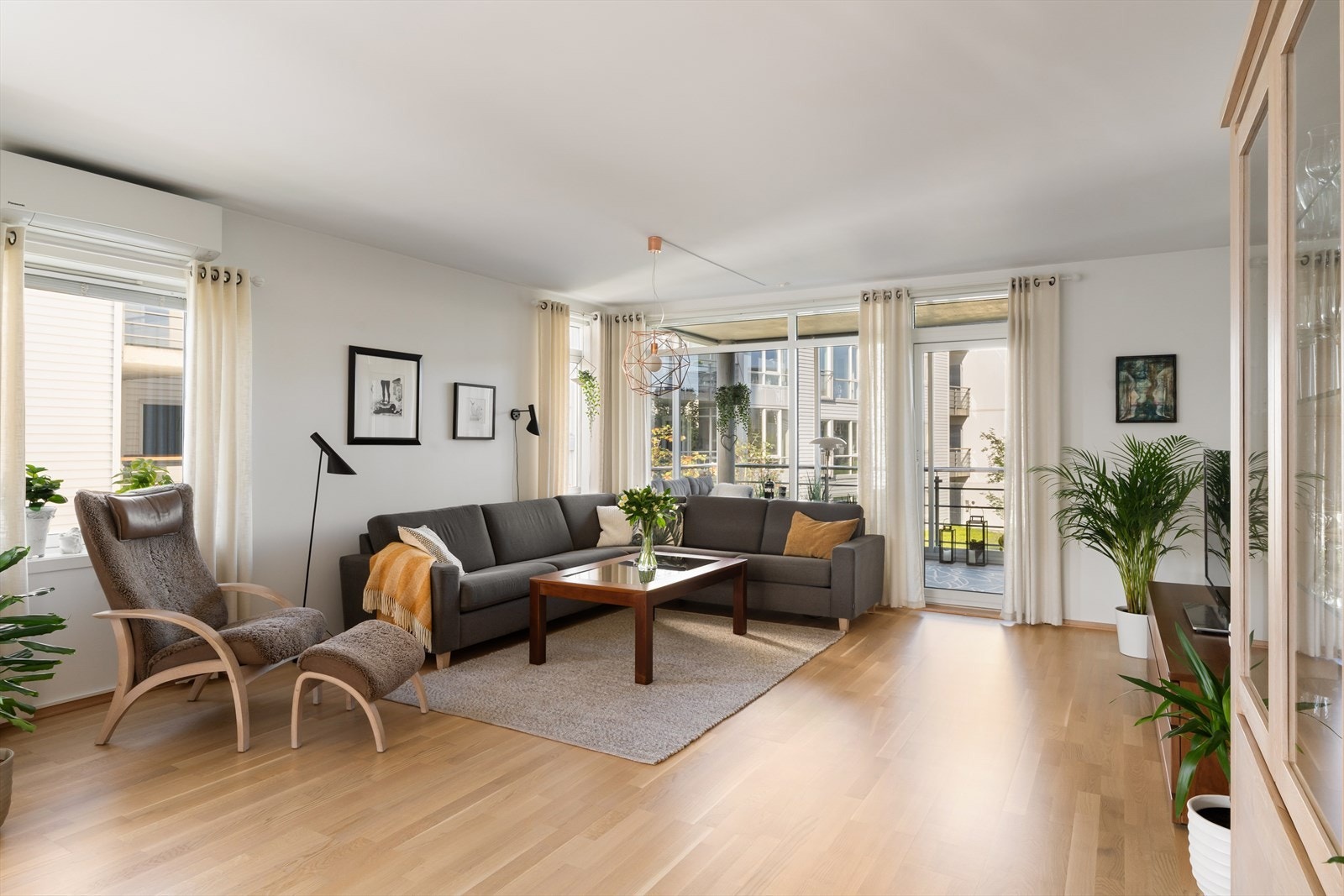 Koselig sofahjørne med utgang til leilighetens innglasserte balkong - varmepumpe montert i 2022 Galleribilde