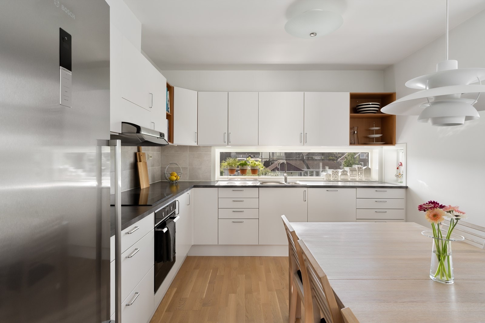 Tidløst kjøkken med slette fronter - rikelig med skap- og benkeplass Galleribilde