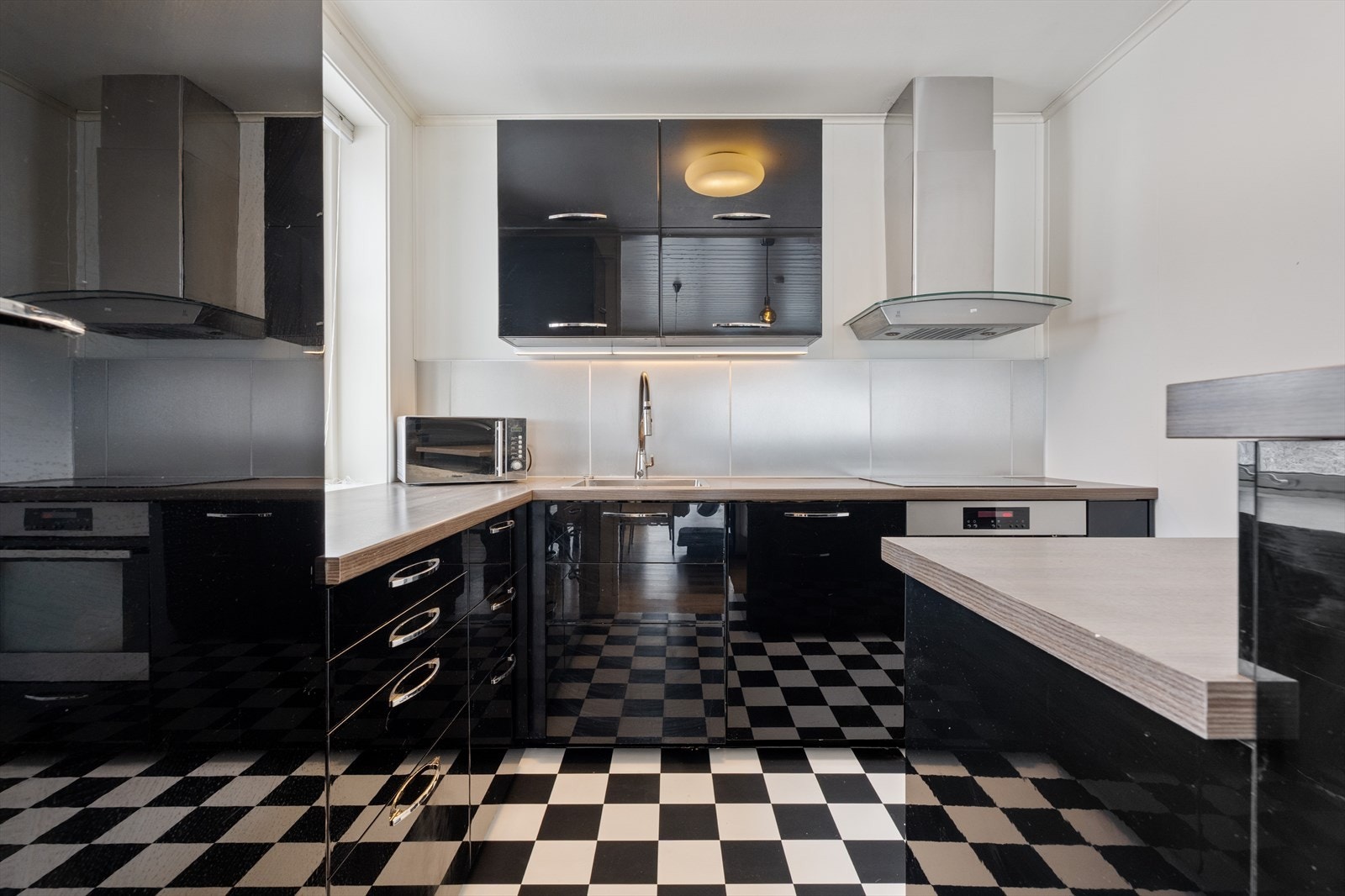 Kjøkken med innredning fra 2013, med glatte fronter og rikelig skap- og benkeplass. Galleribilde