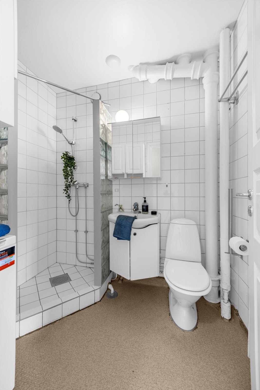 Eldre baderom med fliser i dusjsonen, belegg på øvrige gulvflater og flislagte vegger. Det er i tillegg opplegg for vaskemaskin, toppmatet vaskemaskin kan følge handelen. Galleribilde