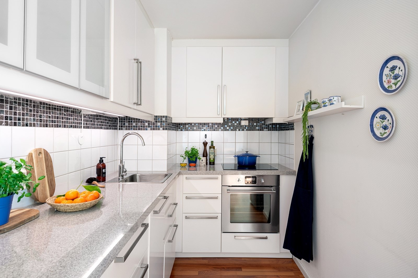 Smal oppvaskmaskin og praktisk plassering av hvitevarer bidrar til en ryddig og effektiv kjøkkenløsning. Galleribilde