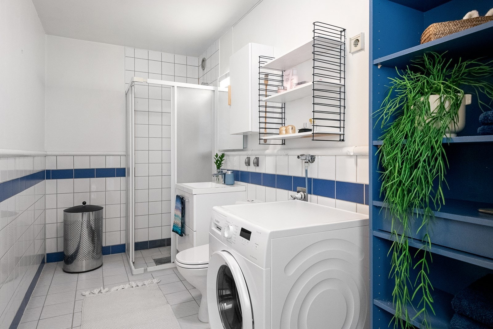 Dusjhjørne med dusjvegger og opplegg for vaskemaskin gir en praktisk og plassbesparende løsning på badet. Galleribilde