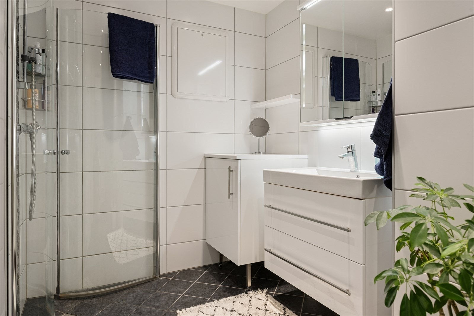 Badet er utstyrt med innredning med nedfelt servant, dusjhjørne, opplegg for vaskemaskin og god lagringsplass. Galleribilde