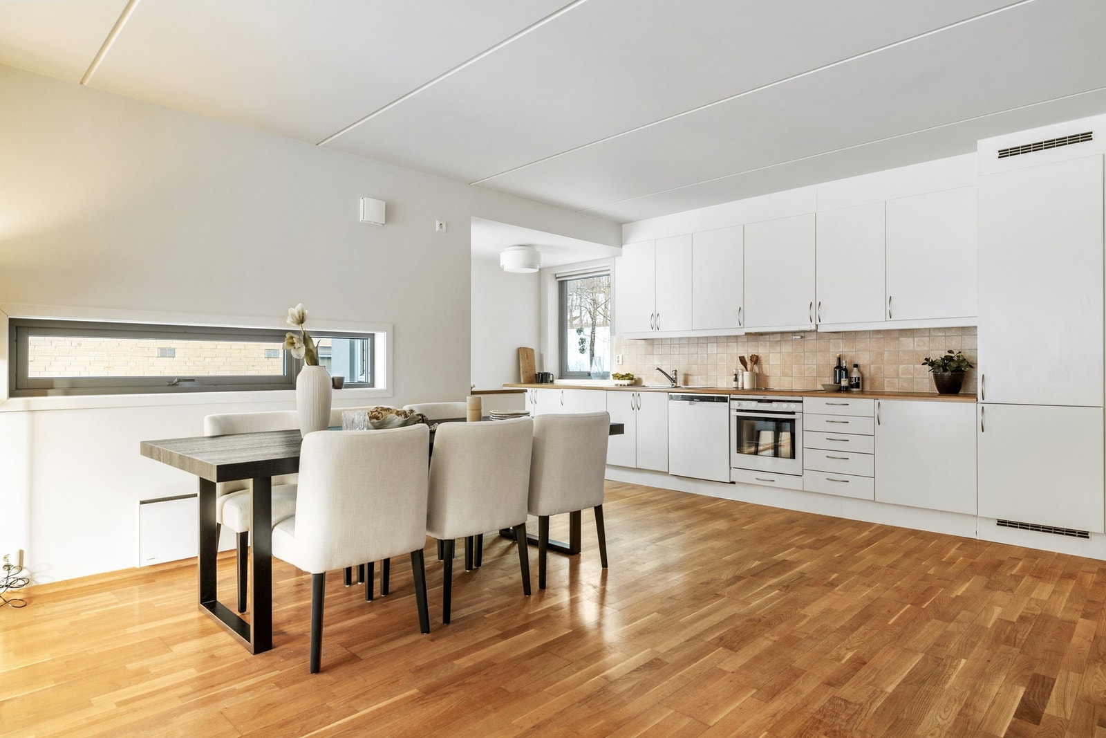 Kjøkkenet er innredet med en lys innredning med glatte fronter, som gir et stilrent og tidløst uttrykk. Galleribilde