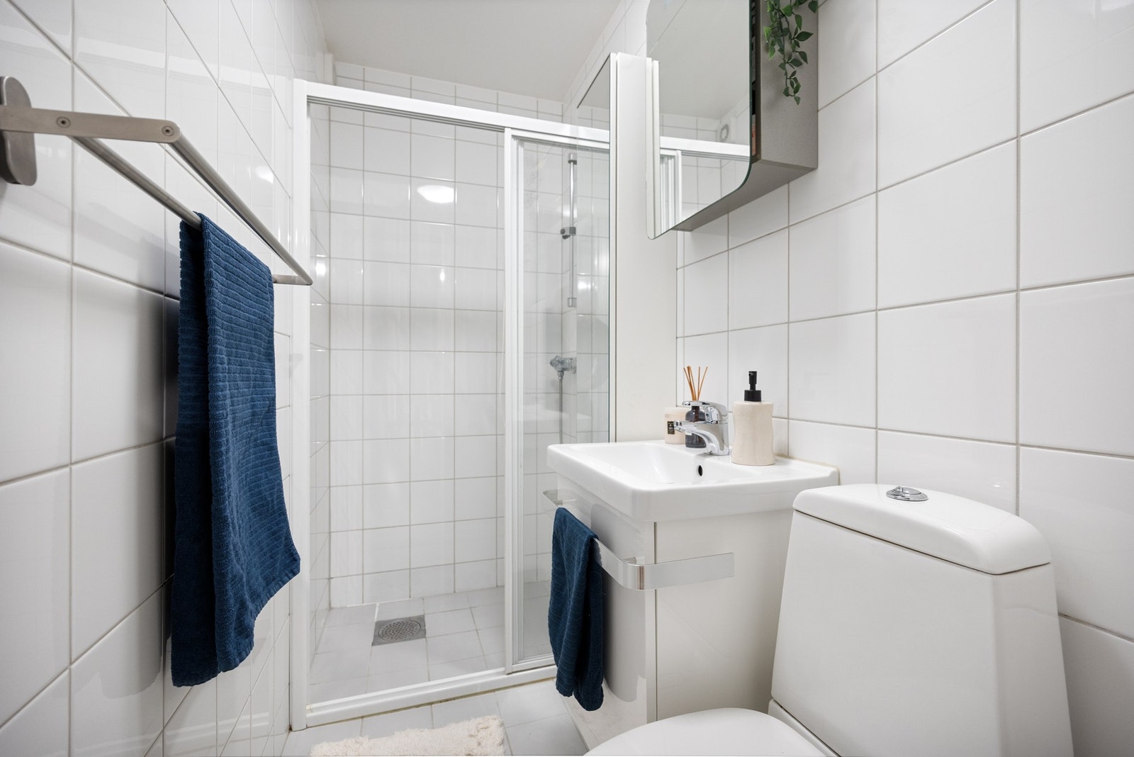 Pent flislagt bad, innredet med toalett, servant og dusj Galleribilde