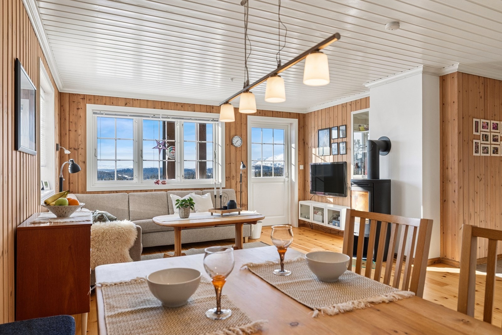 En arealeffektiv leilighet med åpen løsning mellom stue og kjøkken som skaper en luftig og sosial atmosfære. Her flyter sonene naturlig sammen, enten du lager mat eller samler gode venner rundt bordet. Galleribilde