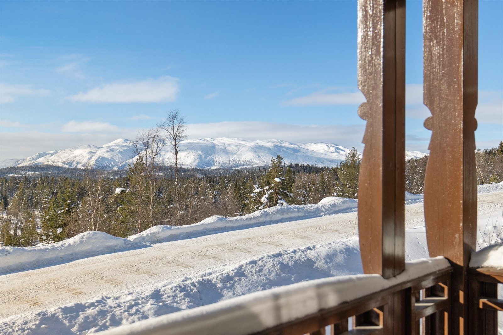 Solrik veranda med åpen og vakker utsikt over landskapet - et sted å starte dagen med kaffe i morgensol og la blikket hvile i det åpne, rolige terrenget. Her sitter du lunt og privat, med naturen tett på og himmelen som nærmeste nabo. Galleribilde