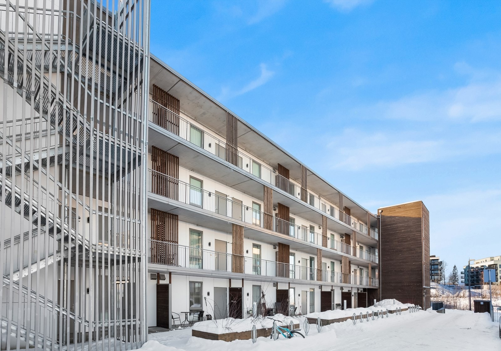 Bygget har en moderne arkitektur med en kombinasjon av trepanel og teglstein. Galleribilde