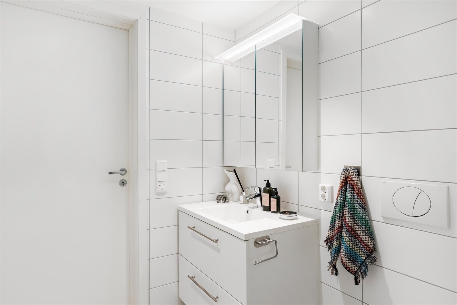 Baderomsinnredning med servant og speilskap med integrert belysning. Galleribilde