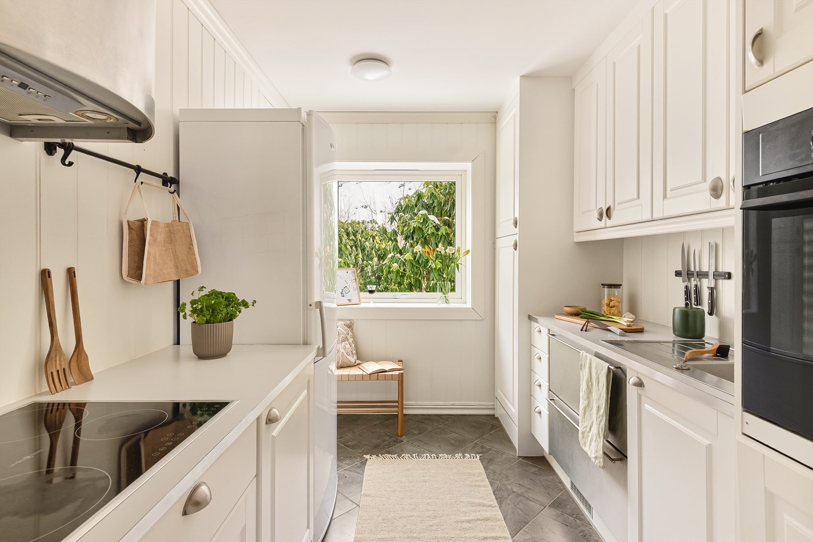 Kjøkkeninnredning fra 2012 med profilerte hvite fronter og takhøy løsning som gir rikelig med oppbevaringsplass. Kjøkkenet har også behagelig varme i gulvet. Galleribilde