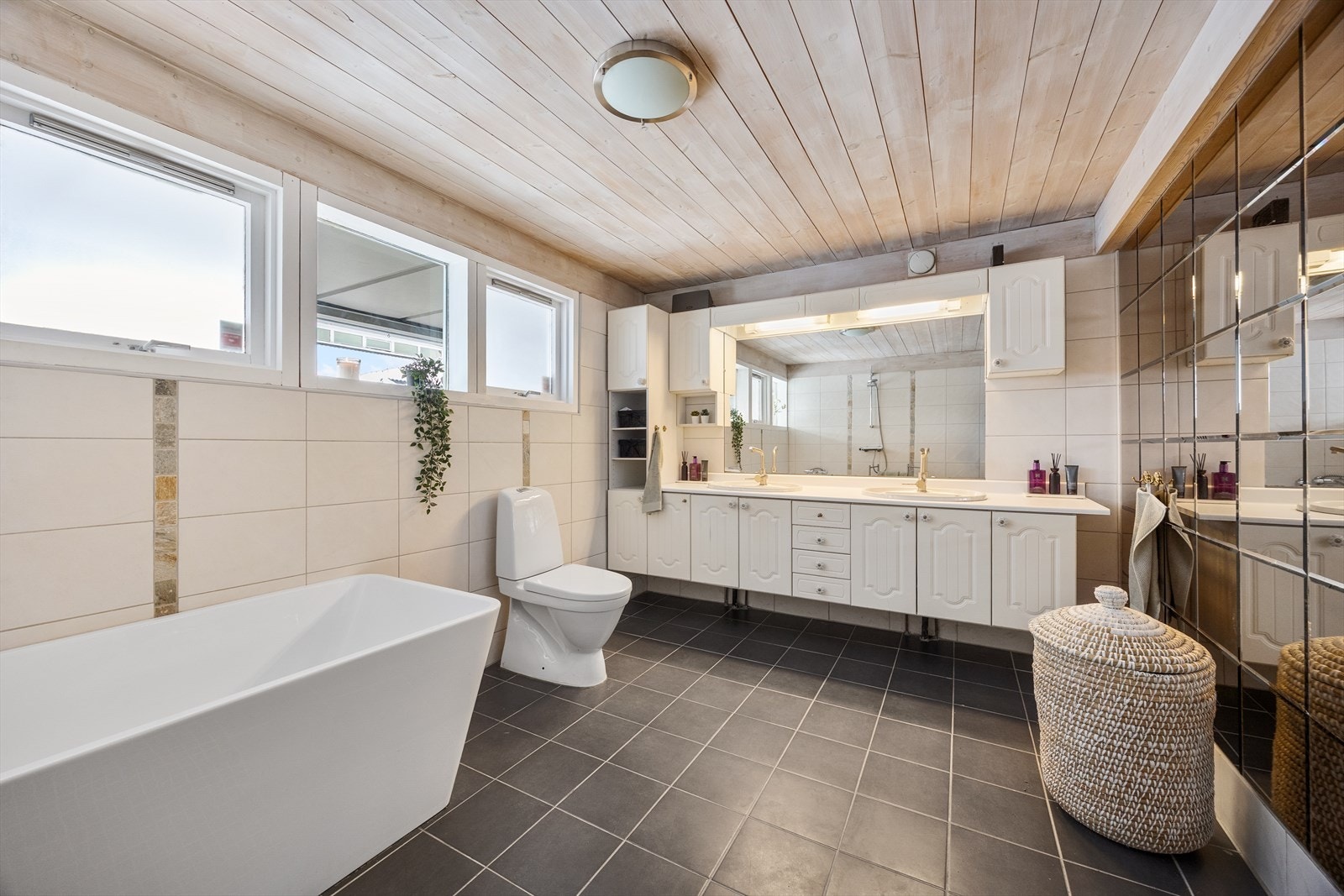 Badet er på ca. 10 kvm og er innredet med delikat fliser, doble servanter og et innbydende badekar. Galleribilde