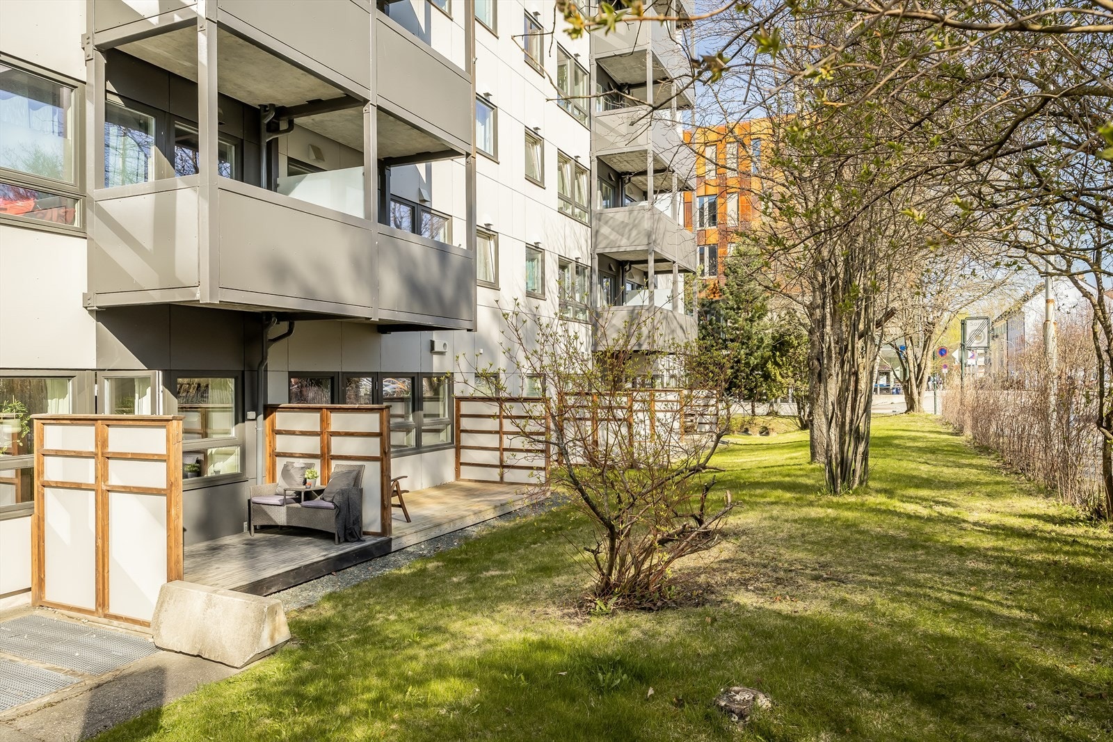 Frodige grøntområder foran terrasse. Veien som går forbi leiligheten er rolig og uten gjennomkjøring. Galleribilde