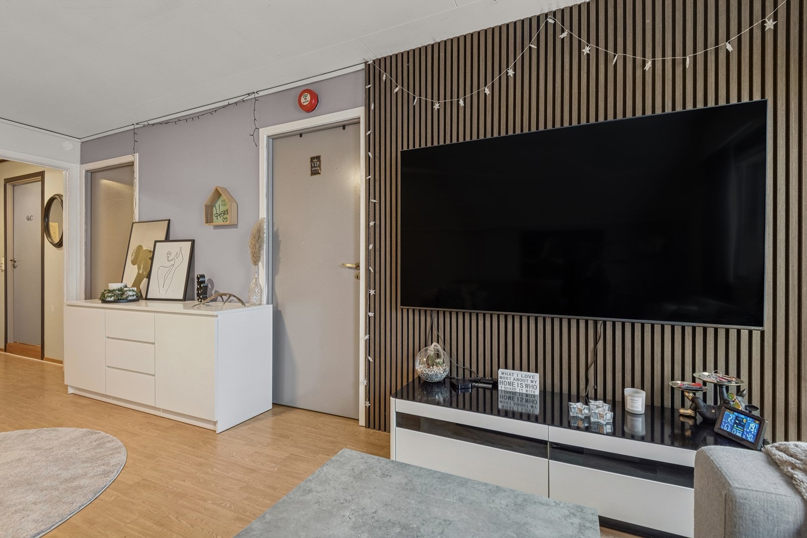 Spileplater (2024) på veggen ved TV-området gir rommet en lun og moderne atmosfære. Galleribilde