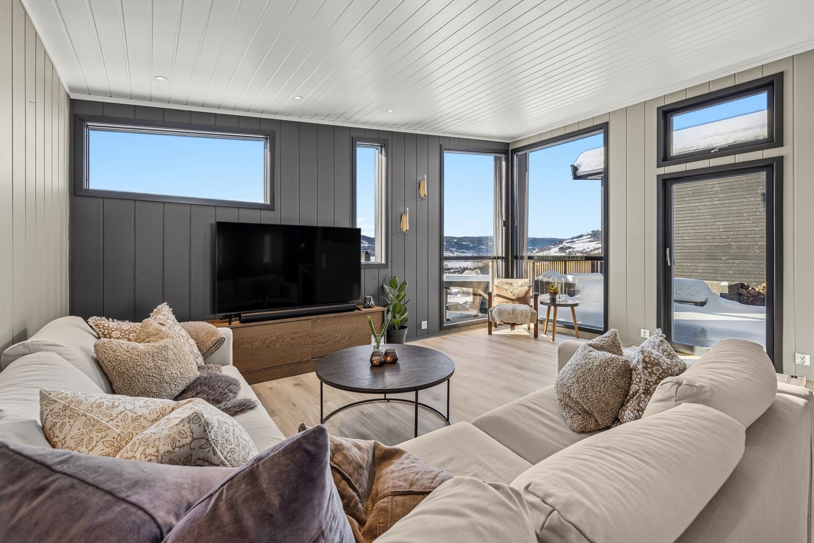 Innbydende stue med god takhøyde og store vindusflater som slipper inn rikelig med naturlig lys. Galleribilde