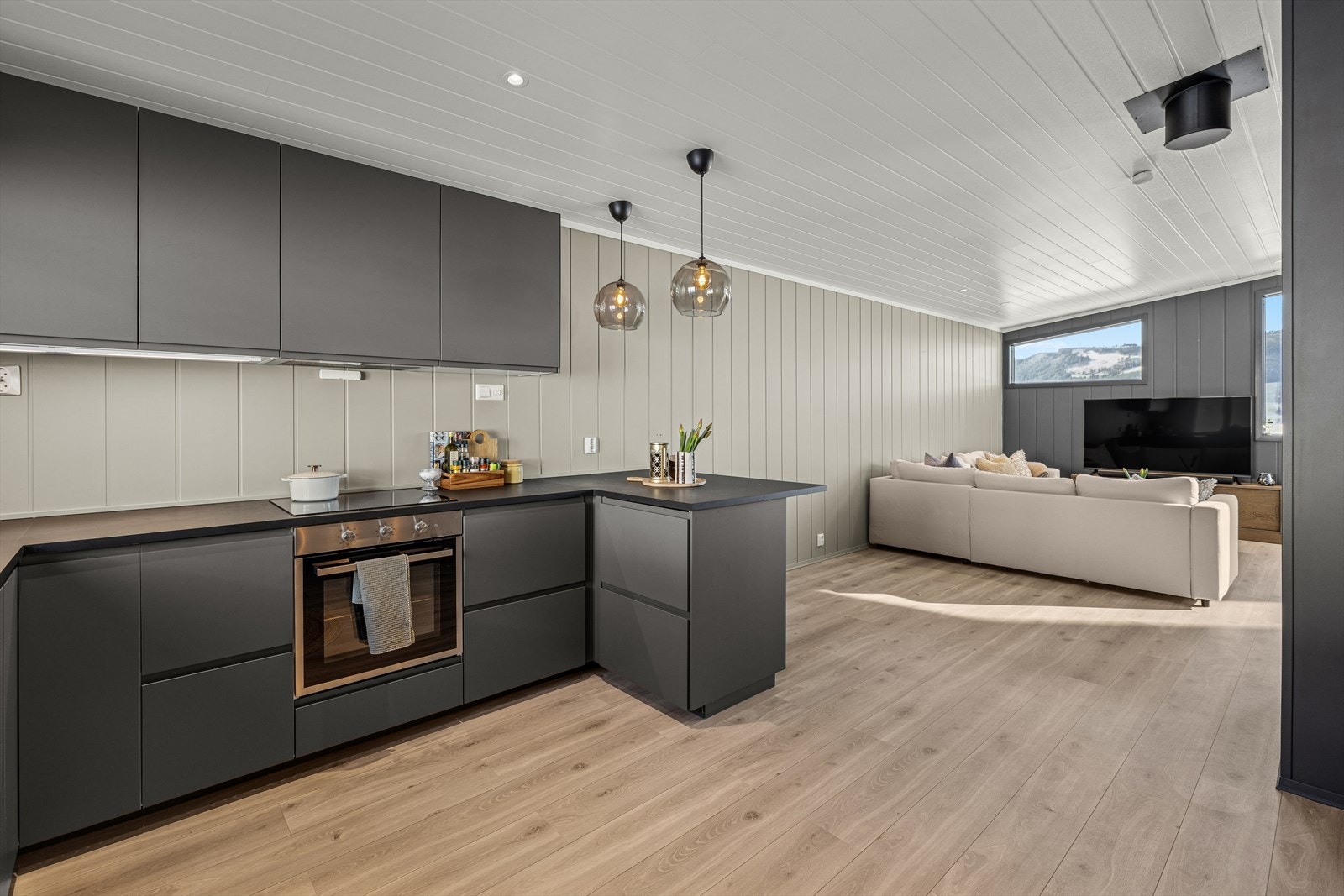 Kjøkkenet har godt med skap og benkeplass. Benkeplaten er også forlenget med mulighet for bar/sitteløsning. Galleribilde