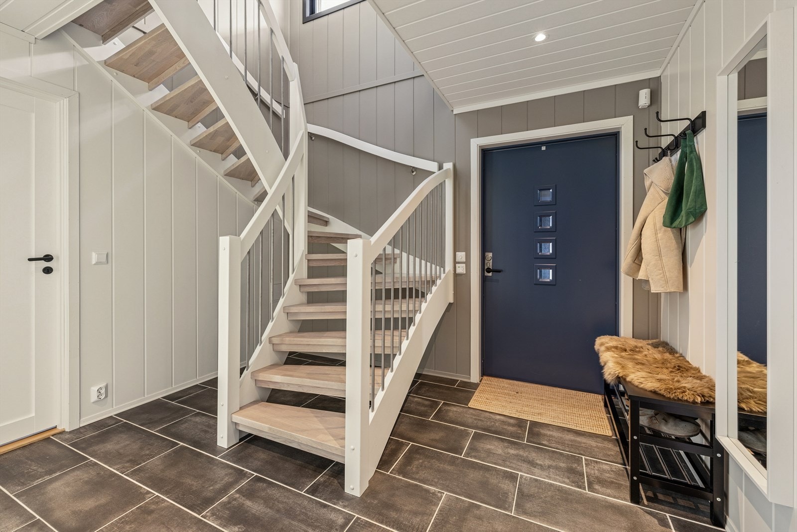 Man ønskes velkommen inn i entréen via overbygget inngangsparti. Her er det er plass til å henge fra seg yttertøy. Fra entréen har du videre adkomst til soverommene, bad og trapp opp til 1. etasje. Galleribilde