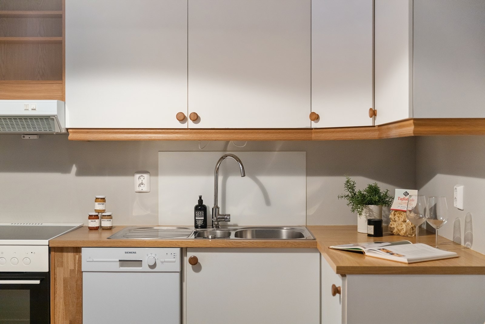 Kjøkkeninnredning med glatte fronter. Laminat benkeplater med nedfelt, stål vaskebeslag. Galleribilde