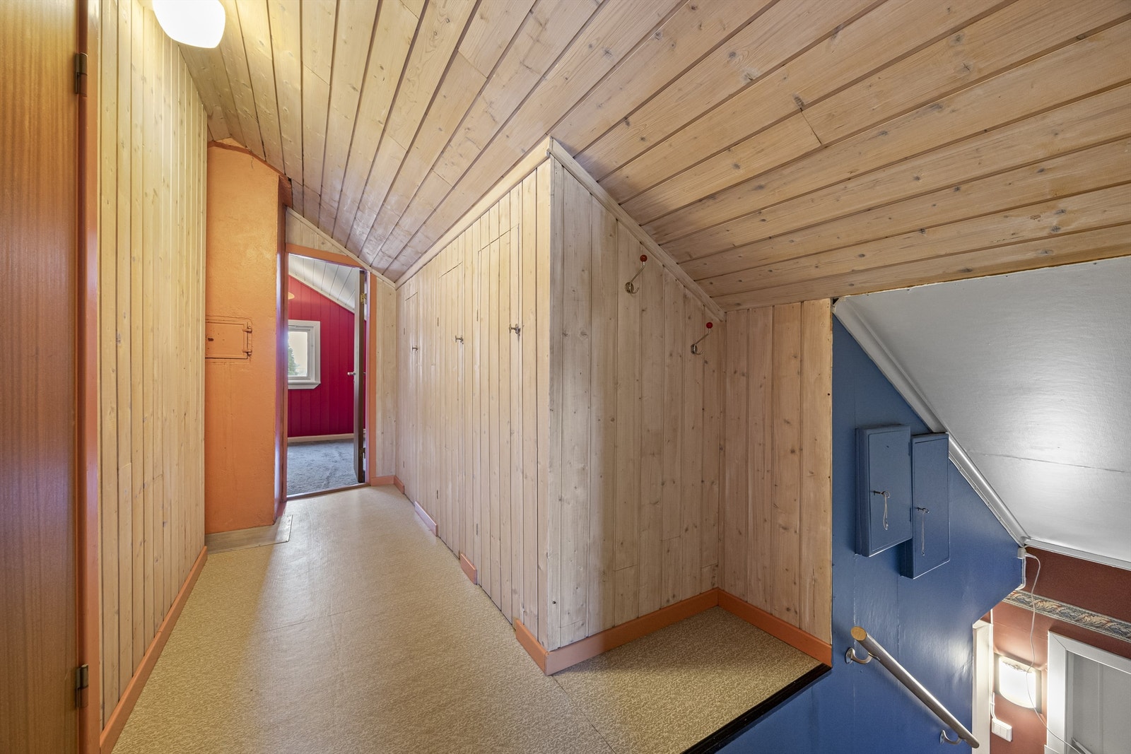En tretrapp leder opp til loftsetasjen, som har panelkledde vegger og tak. Galleribilde