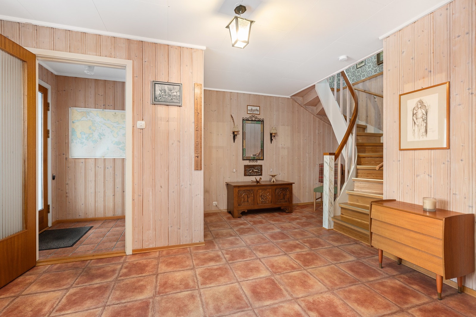 Et romslig inngangsparti i sokkeletasjen (lagringsmuligheter under trappen og i bodareal innenfor vaskerommet). Galleribilde