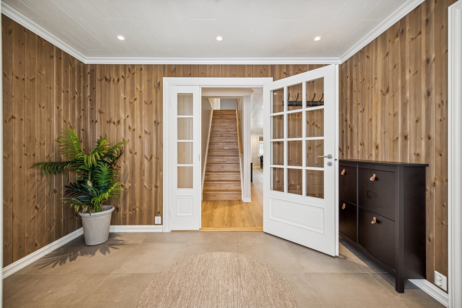 En lakkert tretrapp leder fra gangen opp til andre etasje. Galleribilde