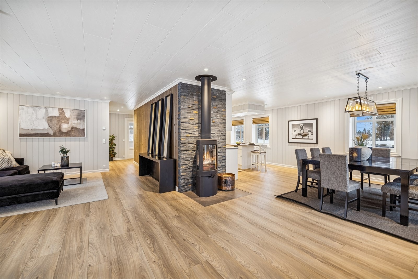 En moderne vedovn fra 2017, med isolert stålpipe, fungerer som et sentralt samlingspunkt. Galleribilde