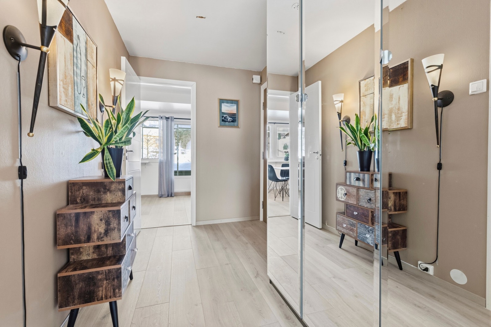 Langs den ene veggen er det et romslig garderobeskap med speilfronter Galleribilde