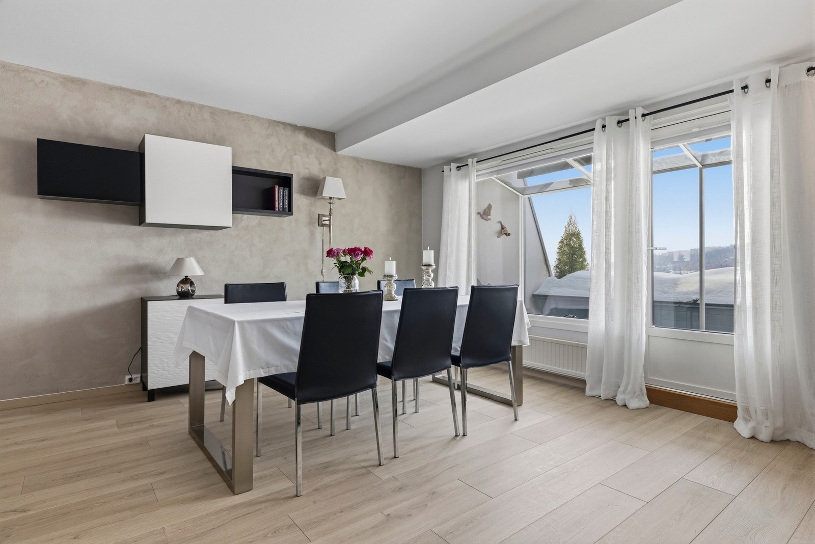 Store vindusflater slipper inn godt med naturlig lys og bidrar til et lyst og trivelig oppholdsrom Galleribilde