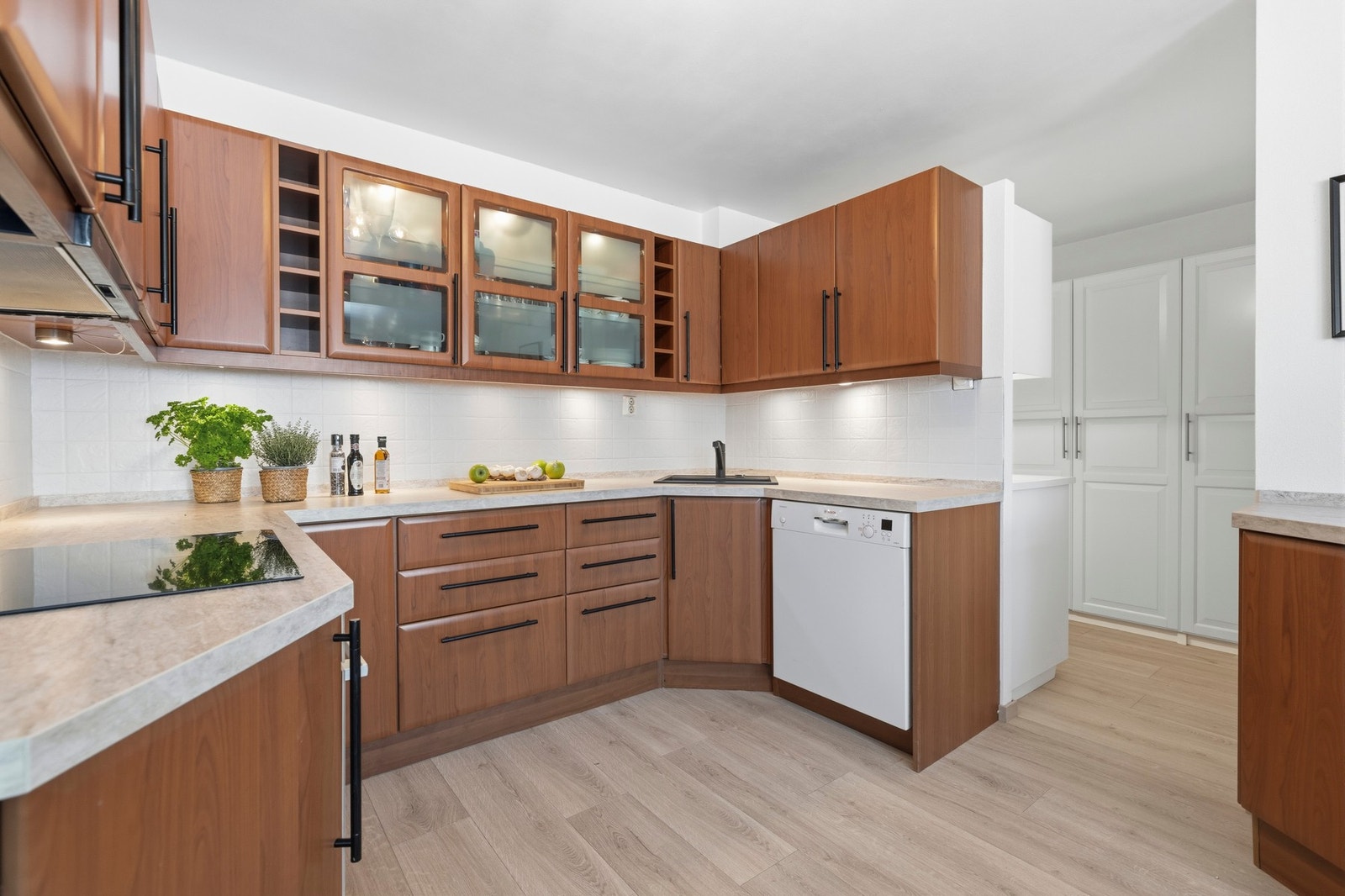 Kjøkkenet er utstyrt med integrerte hvitevarer som platetopp og komfyr, samt en oppvaskkum i stål Galleribilde