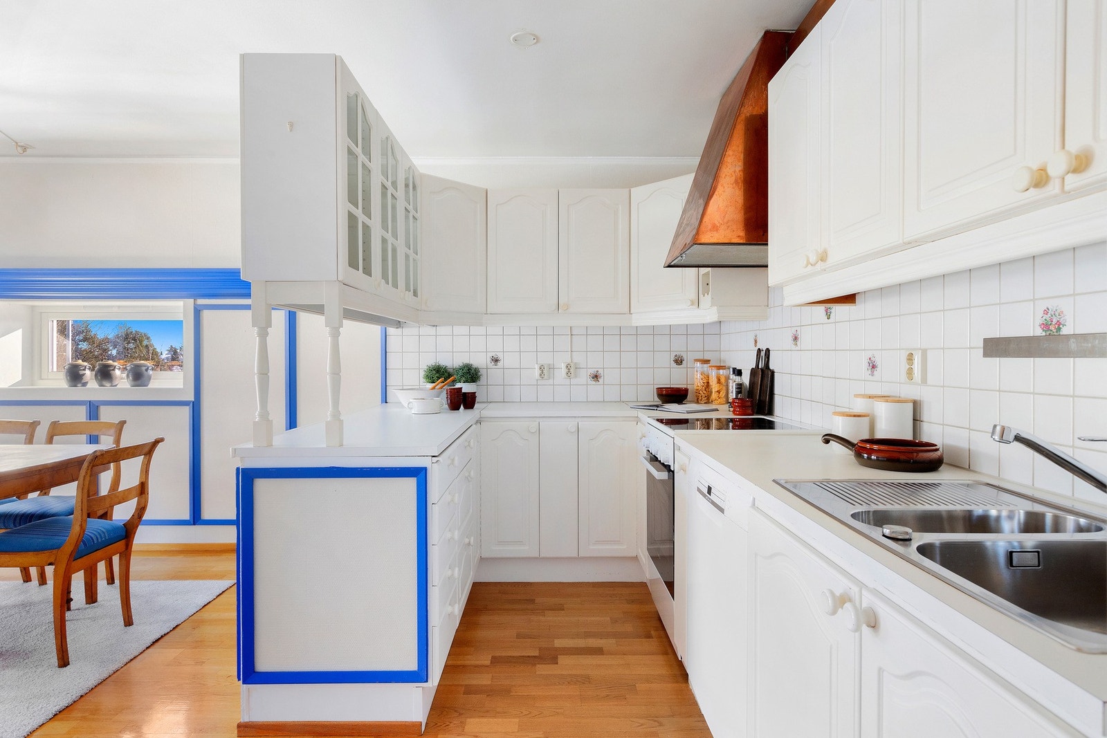 Kjøkkenet har hvit profilert innredning med barløsning. Frittstående hvitevarer. Galleribilde