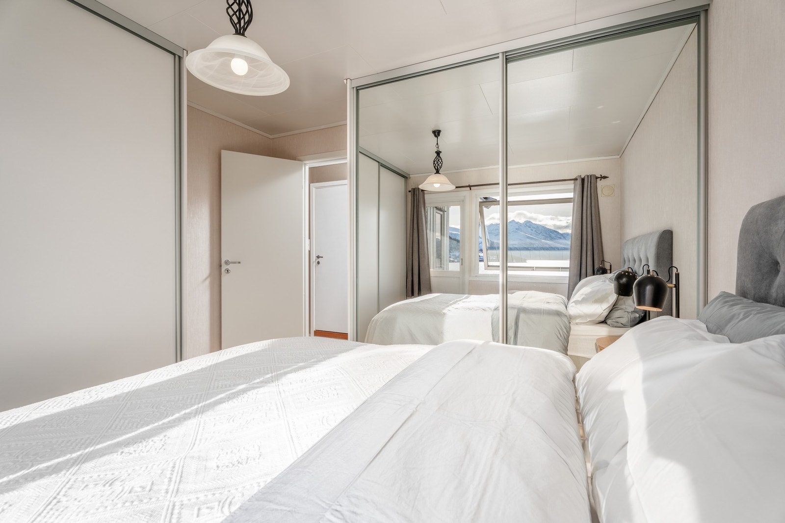 Rommet er utstyrt med skyvedørsgarderober. Legg merke til speilflatene som fanger opp omgivelsene. Galleribilde