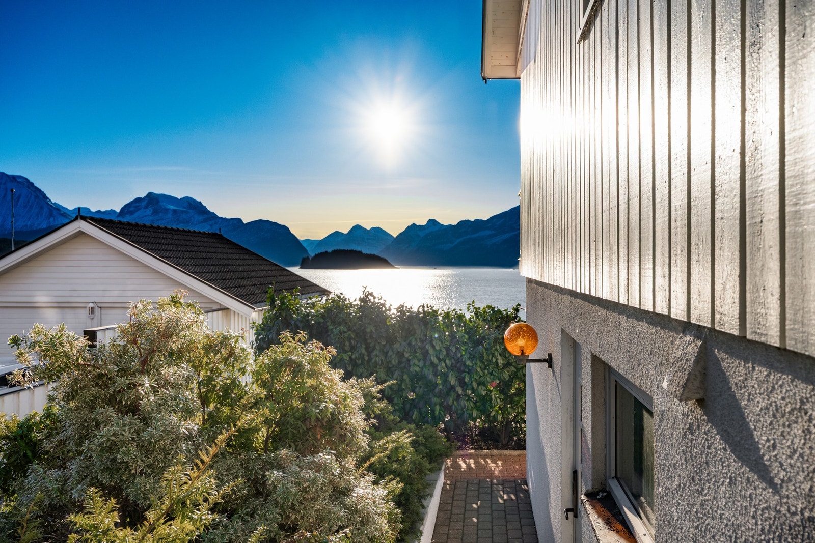 På østsiden er det tilkomst til utleiedelen. Legg merke til pen beplantning og den vakre utsikten. Galleribilde