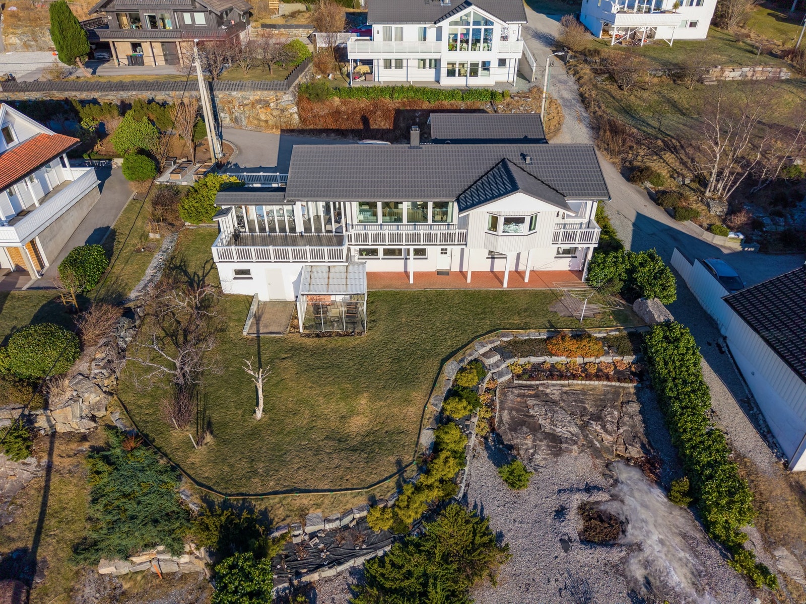 Tomten har både beplantet grøntareal, flotte natursteinsmurer og vasket berg. En vakker og unik kombinasjon. Galleribilde