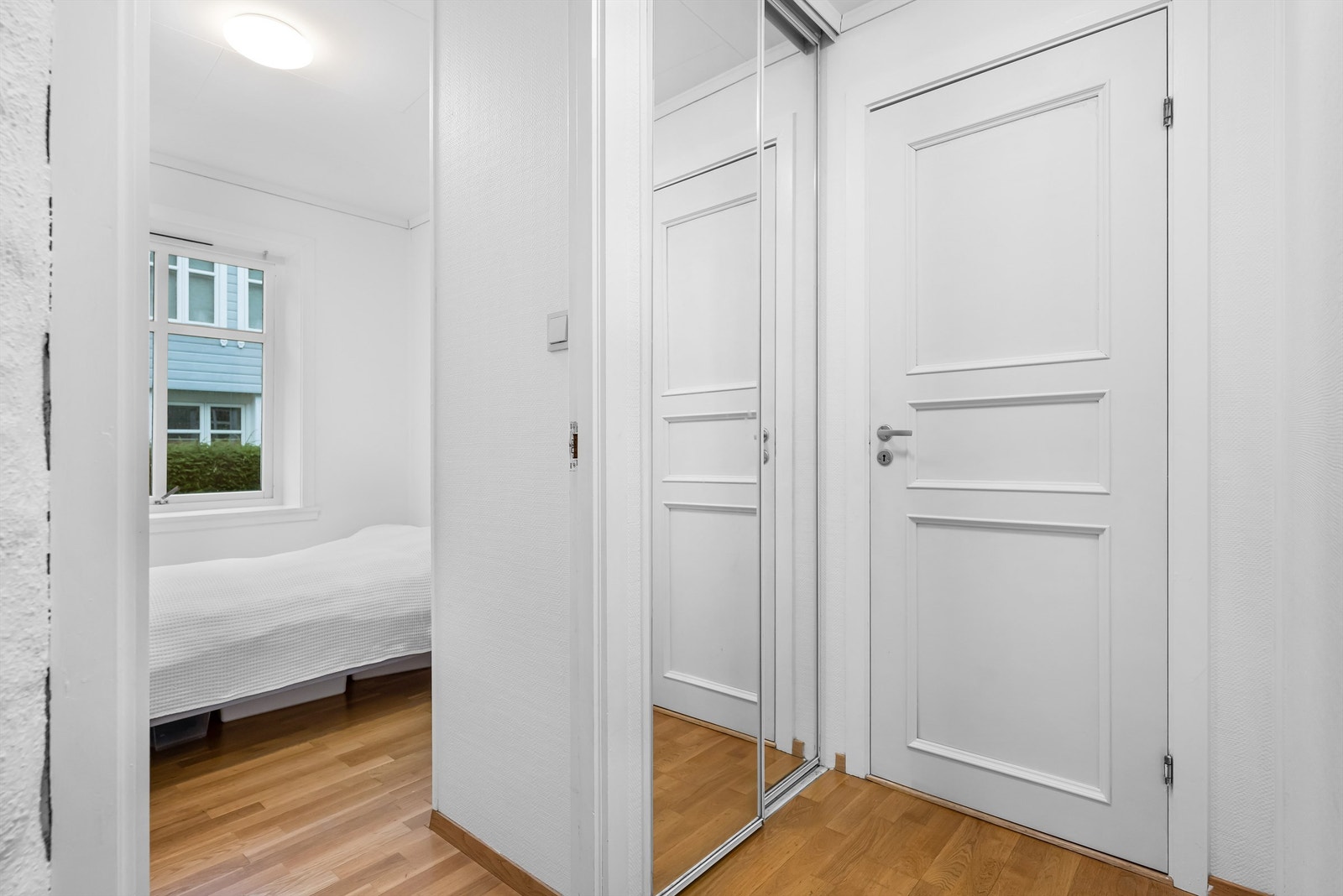 Til venstre i gangen er det montert skyvedørsgarderobe med speil. Dørene på bildet går inn til hvert av soverommene Galleribilde