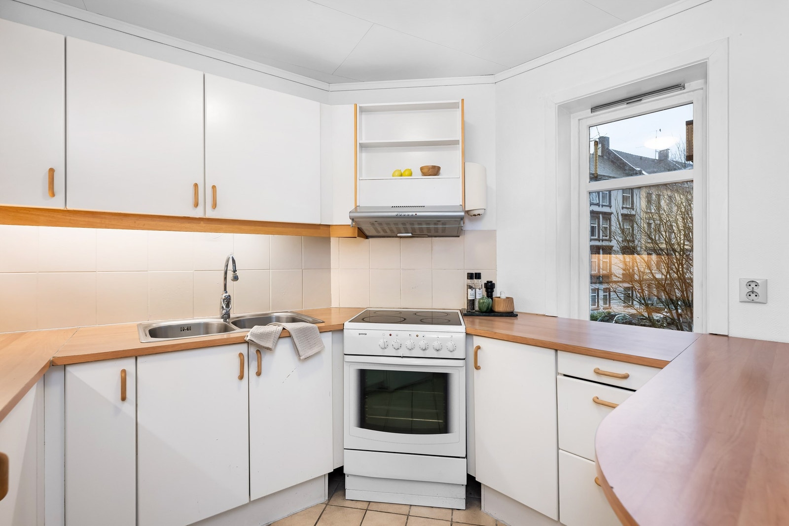 Kjøkkenet er fra ukjent årstall med glatte fronter og benkeplate av laminat. Mellom kjøkkenbenk og overskap er det fliser. Galleribilde