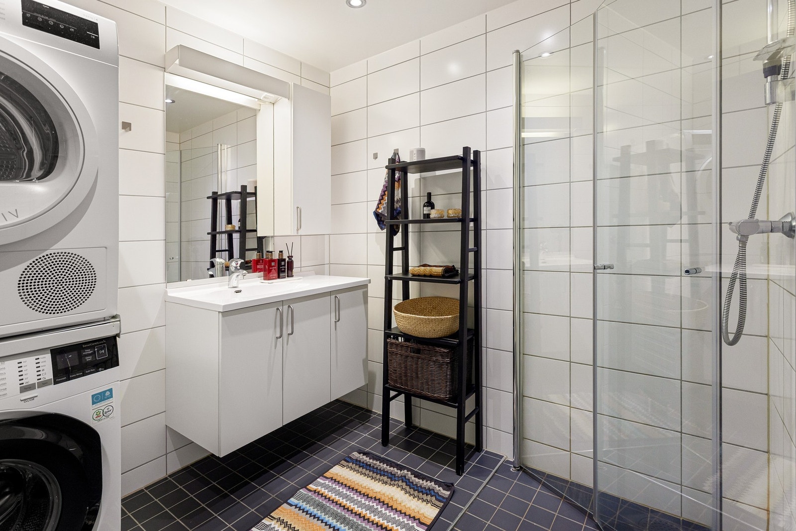 På badet er det grå fliser på gulv med varme og lyse fliser på vegger. Galleribilde