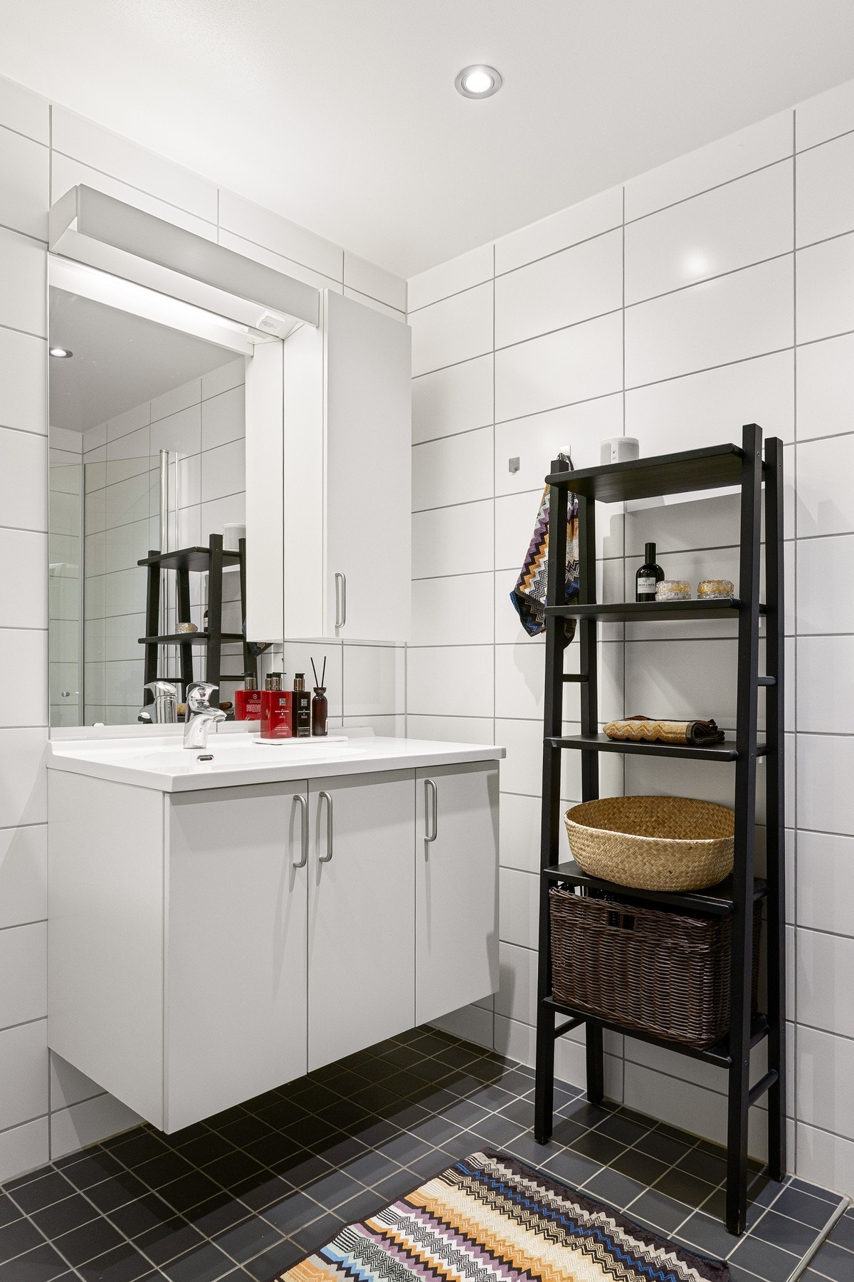 Innredningen består av servant på underskap, speil med overbelysning og vegghengt toalett. Videre er det dusjhjørne med innfellbare glassdører som frigjør plass på gulvet. Galleribilde