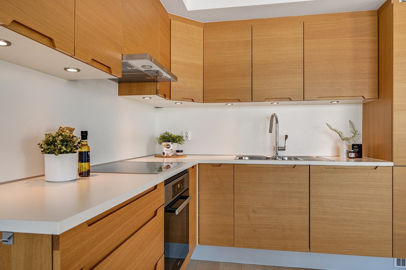 Kjøkkenet ligger i en åpen løsning mot stuen og er utført i moderne stil med lys under overskapene. Galleribilde