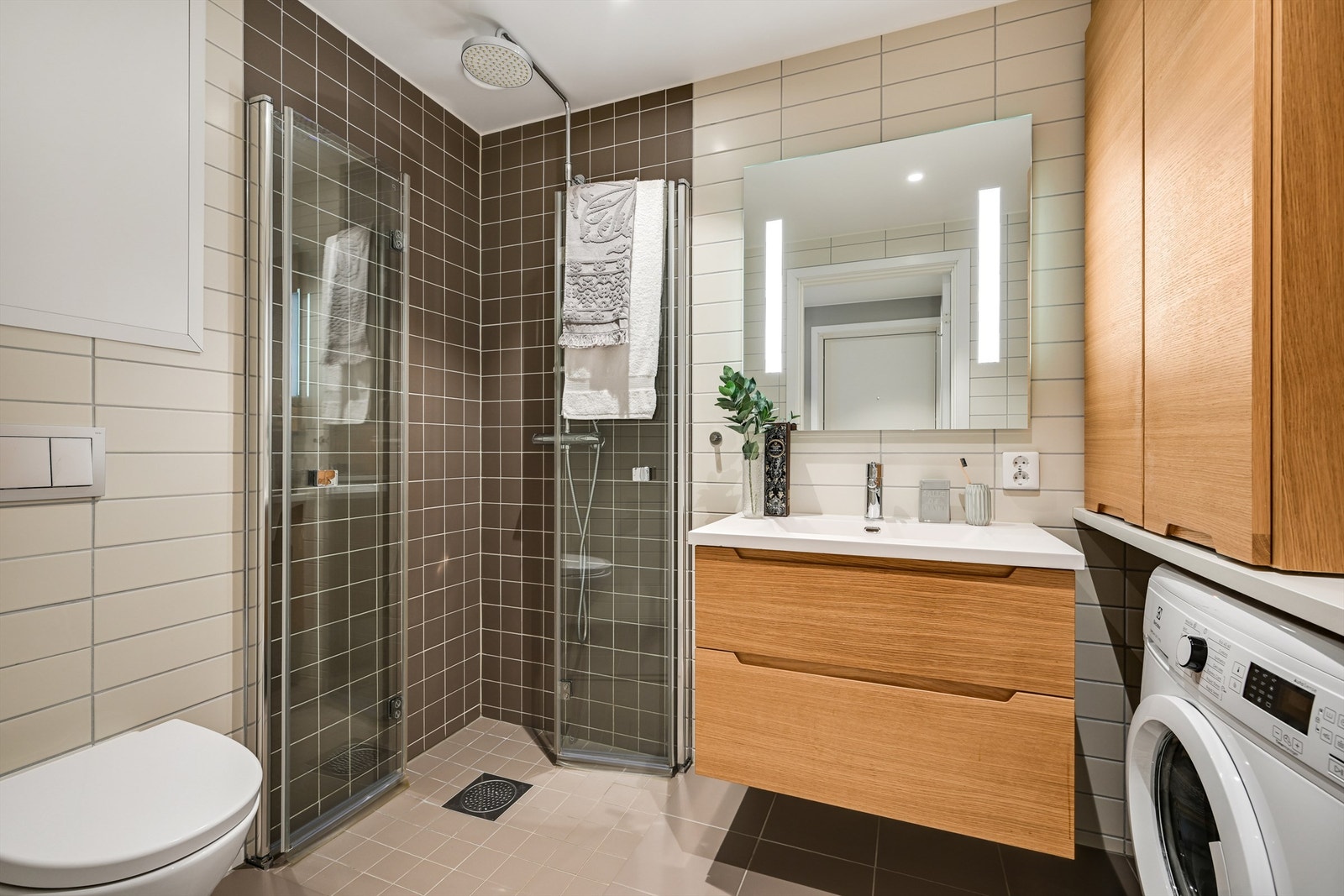 Det er innredet med en delikat servant med skuffer under, spotter i taket, toalett og dusjhjørne med innfellbare glassdører. Galleribilde