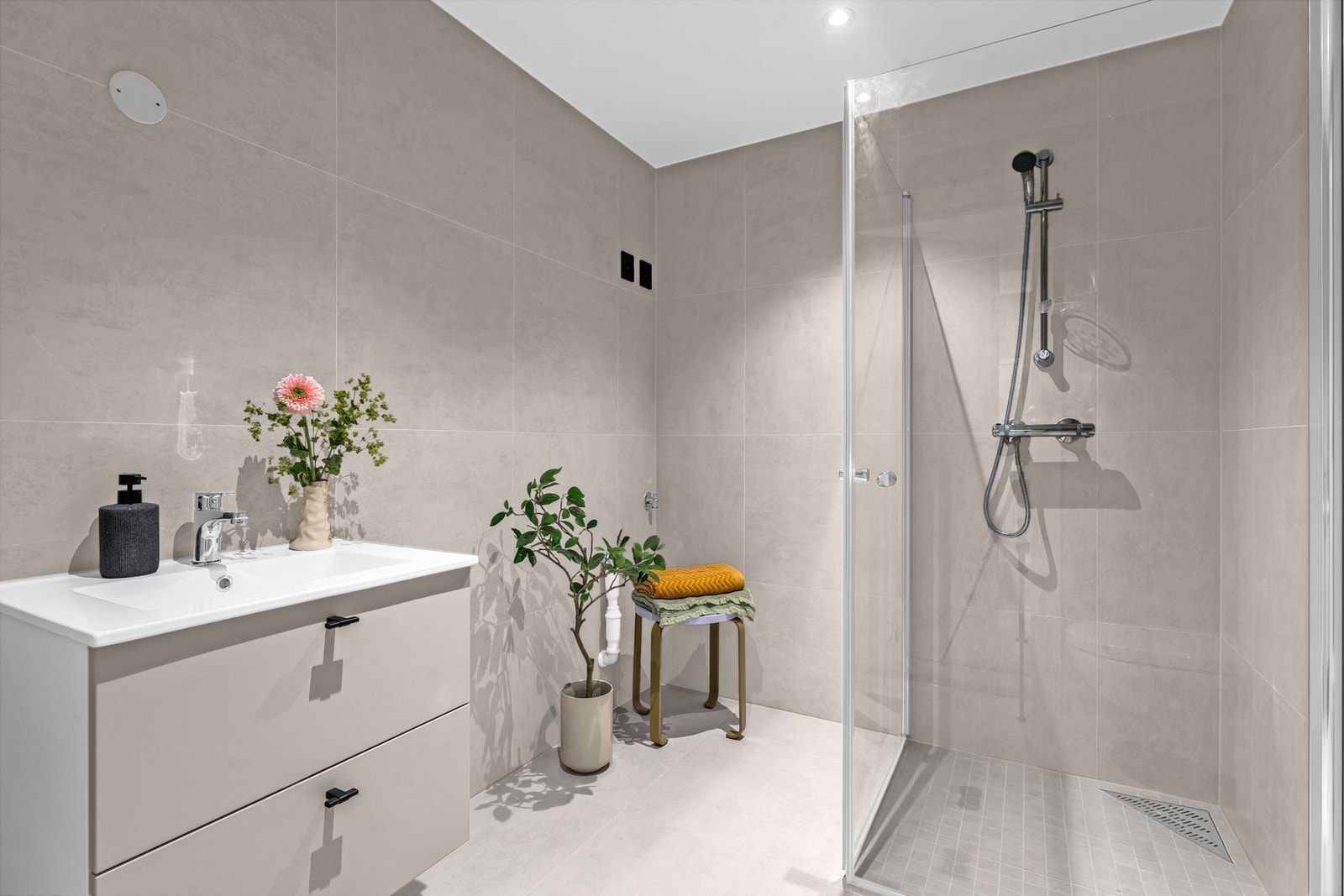 Stilrent baderom med store fliser og gjennomført finish. Galleribilde