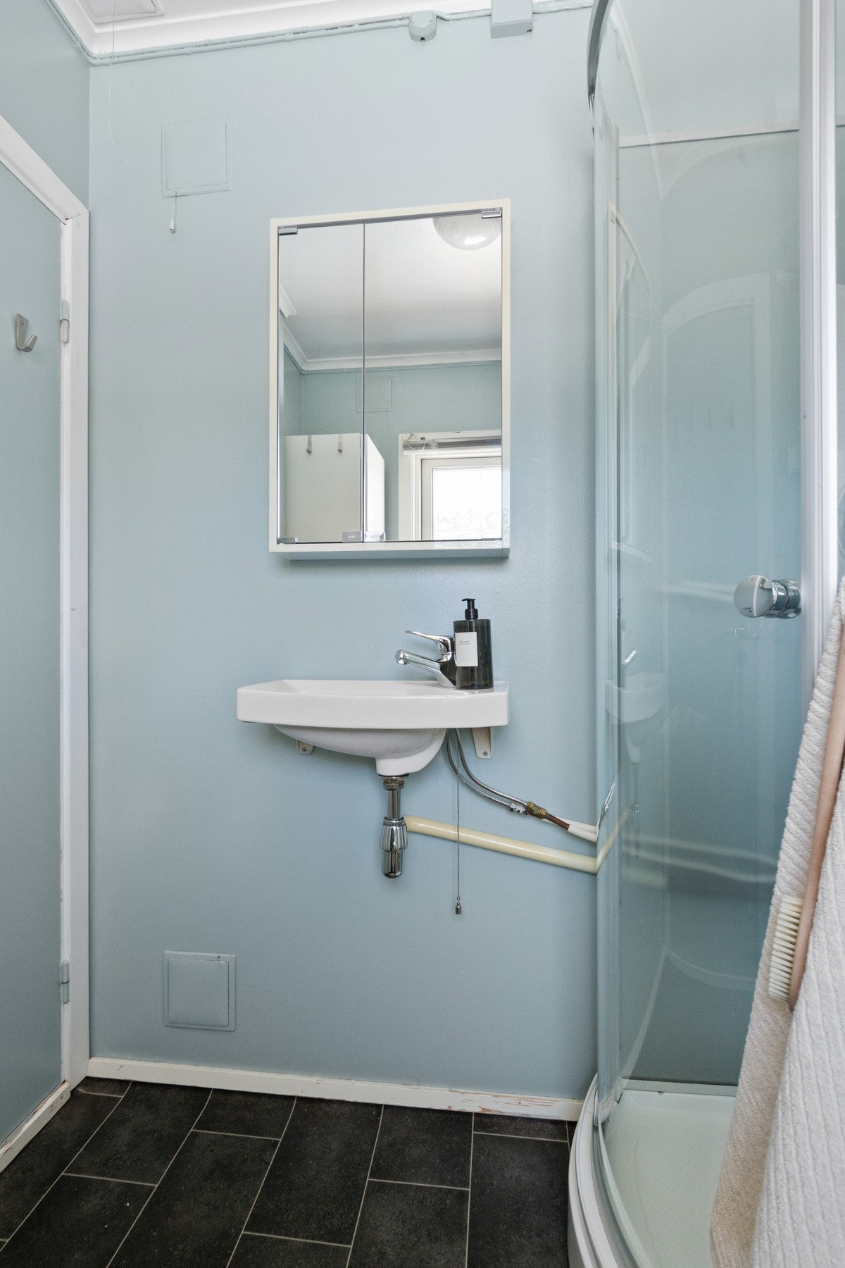 Badet er innredet med vegghengt servant og speilskap. Galleribilde