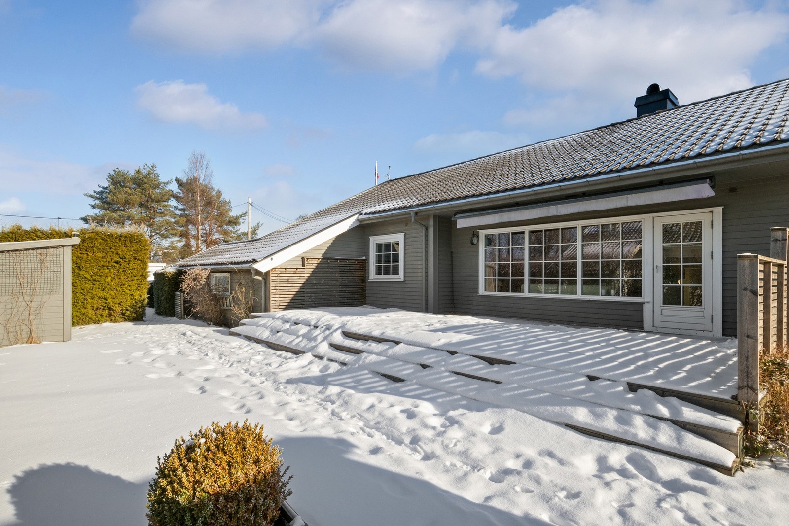 Uteområdet er godt skjermet med hekk og har en romslig terrasse på baksiden av boligen. Galleribilde