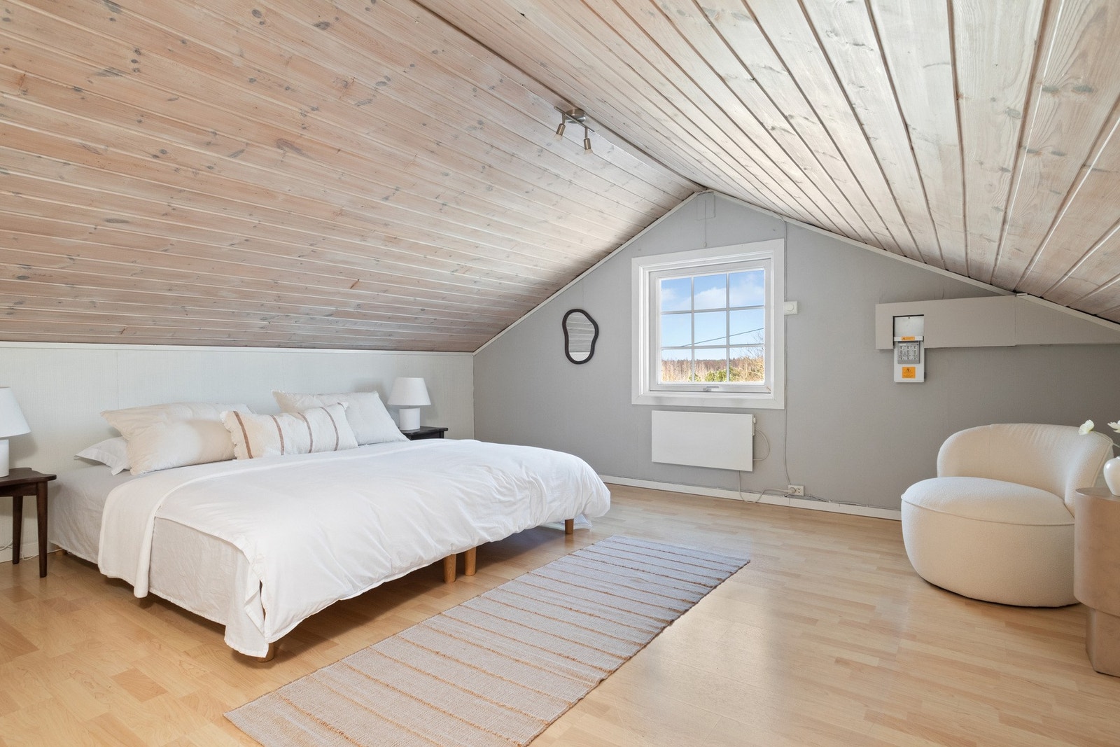 To av soverommene ligger i andre etasje og har et sjarmerende preg med mønet tak og hvitlakkert trepanel i himling. Galleribilde