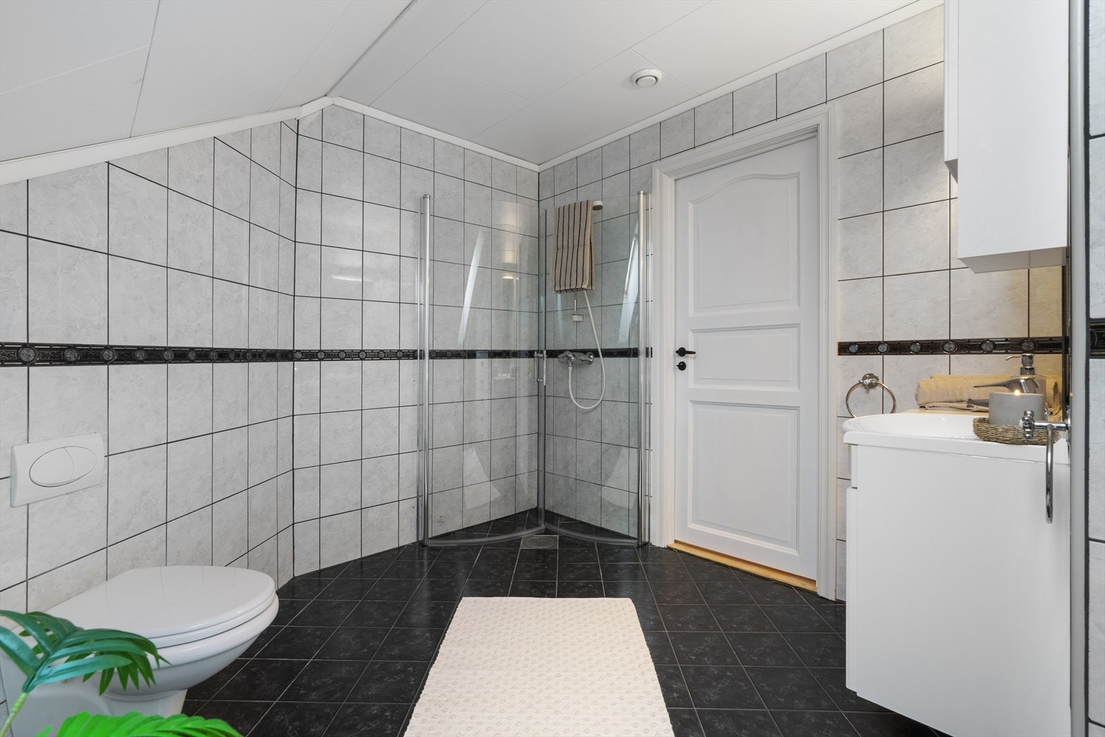 - Badet er innredet med vegghengt toalett, benkeskap med servant og innfellbare dusjdører i glass - Galleribilde